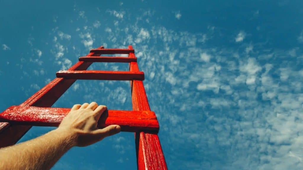 Red wooden ladder pointing to the sky